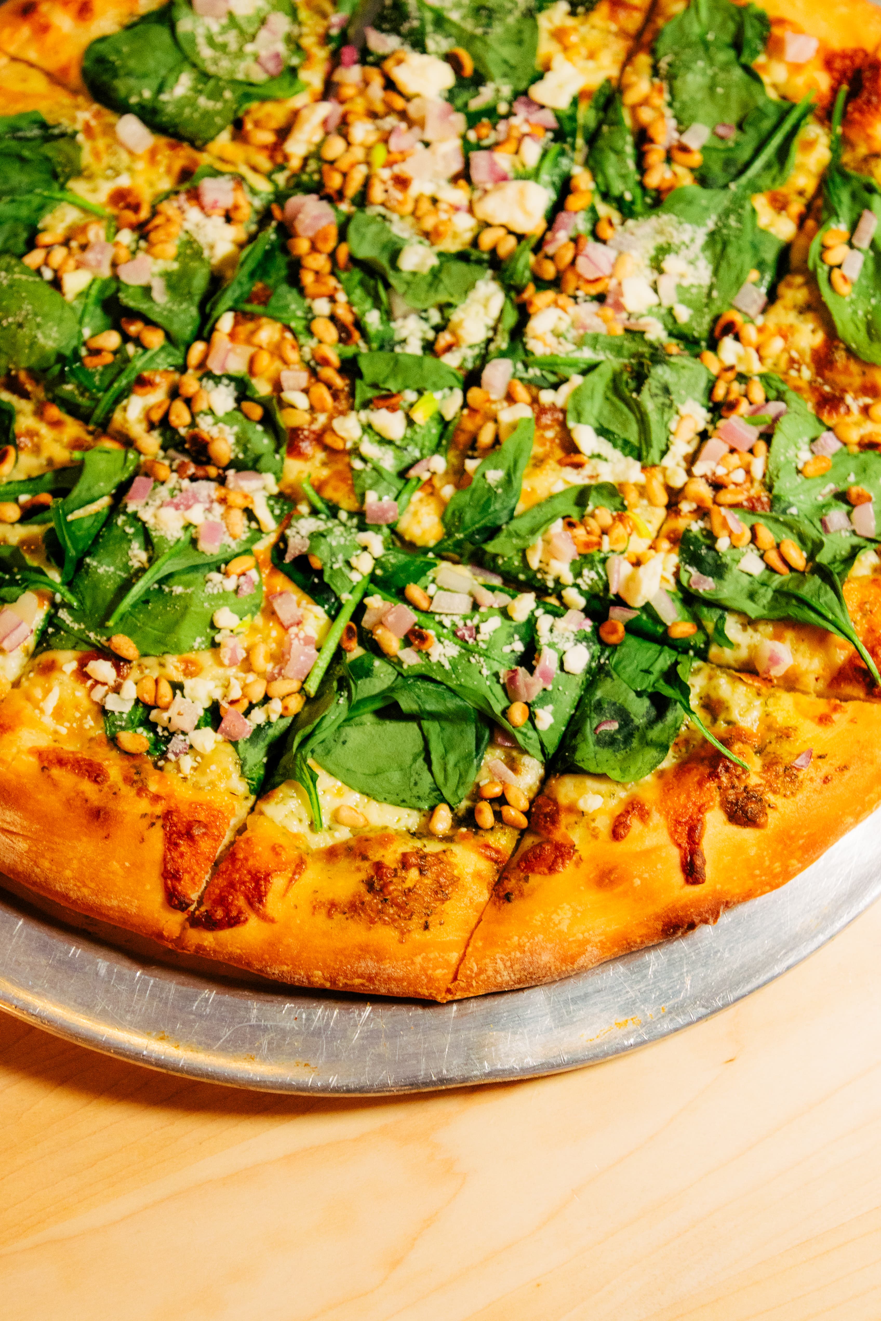 Spinach pesto stone-fired pizza at Harper's Restaurant & Brewpub in East Lansing  house-made pesto, goat and feta cheese