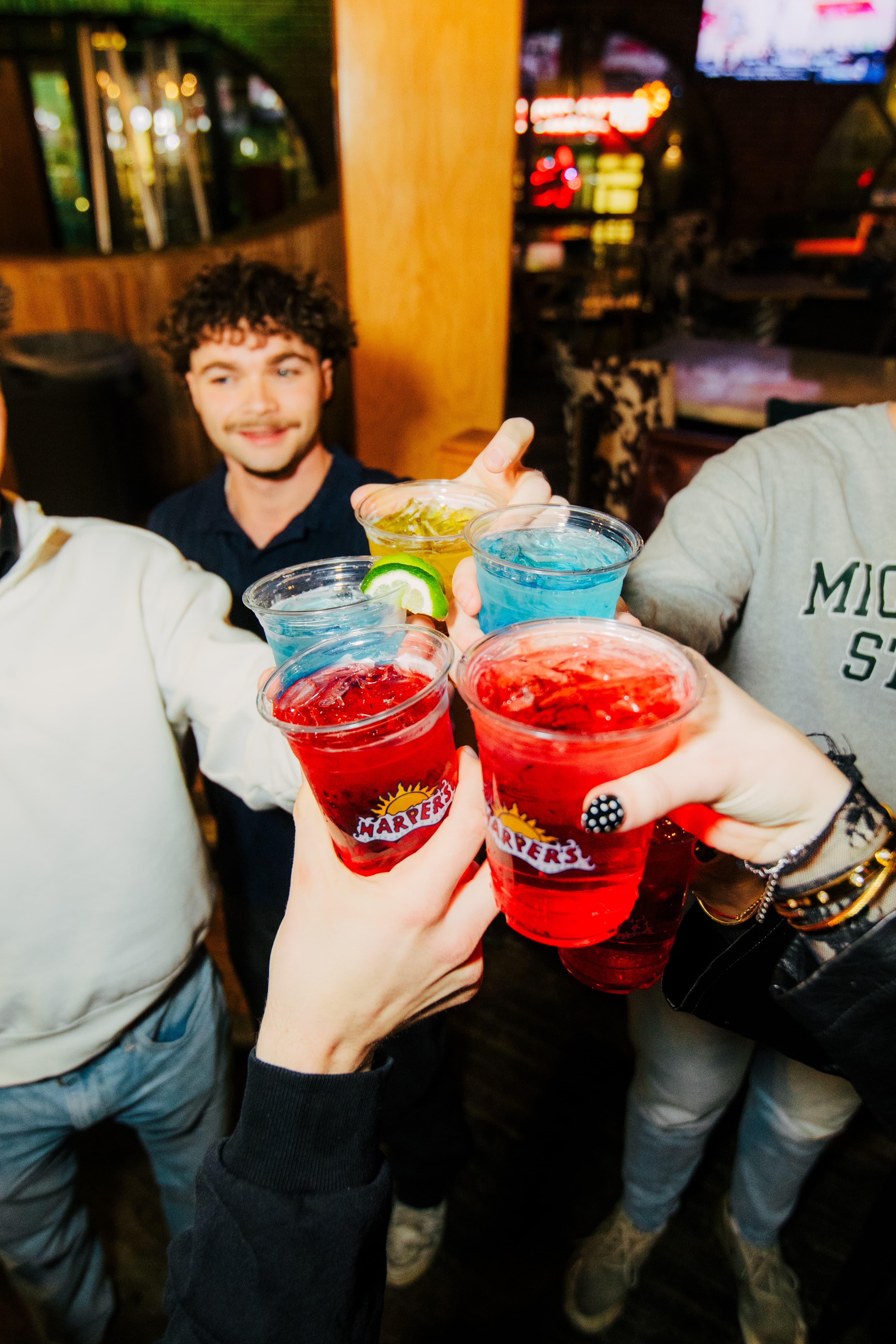 MSU students cheersing drinks at Harper's bar in East Lansing